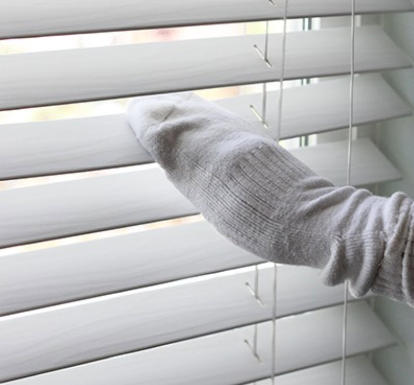 Use a pair of socks to clean your blinds